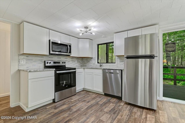 kitchen featuring stainless steel appliances, dark wood-type flooring, and white cabinets