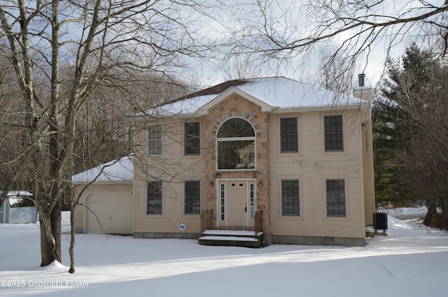 colonial-style house featuring a garage and central AC unit