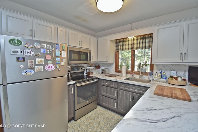 4462 Woodside Dr, East Stroudsburg, PA 18301 - kitchen with stainless steel appliances, decorative backsplash, white cabinets, and light stone countertops