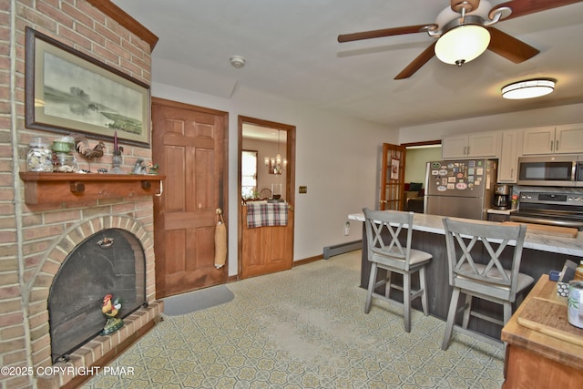 4462 Woodside Dr, East Stroudsburg, PA 18301 - kitchen featuring appliances with stainless steel finishes, white cabinetry, light countertops, ceiling fan, and a baseboard radiator