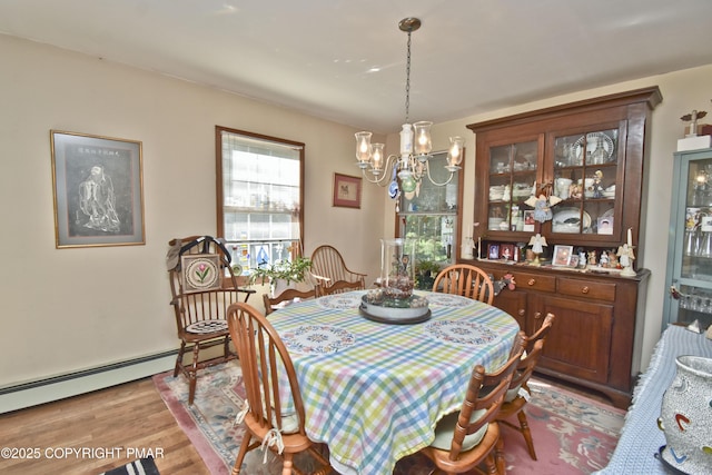 4462 Woodside Dr, East Stroudsburg, PA 18301 - dining area with a chandelier, wood finished floors, and a baseboard radiator