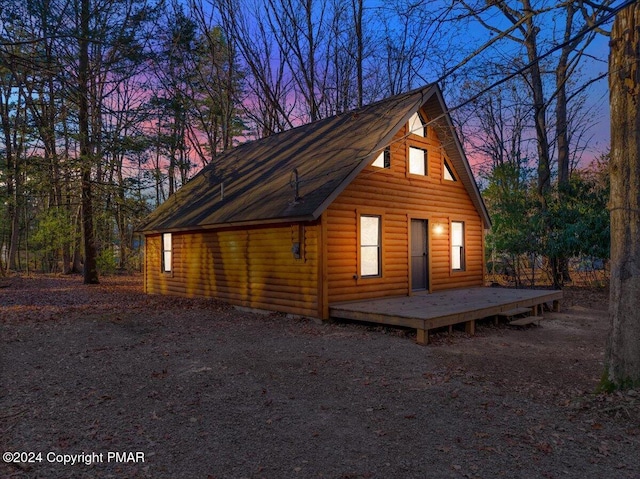 view of property exterior featuring log veneer siding and a wooden deck