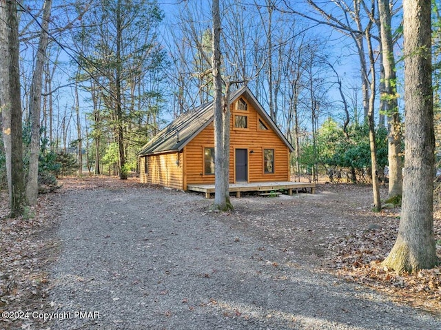 view of home's exterior with faux log siding and a deck