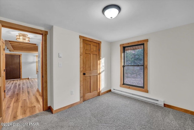 unfurnished bedroom featuring a baseboard radiator, baseboards, and light colored carpet