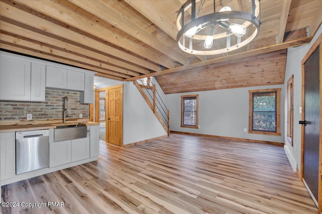 interior space with open floor plan, a sink, butcher block countertops, light wood-type flooring, and dishwasher