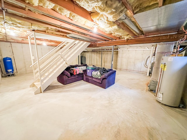 unfinished basement featuring water heater, a water pressure tank, and stairs