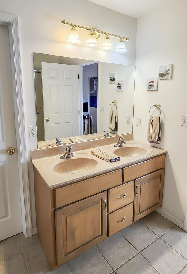 full bathroom featuring tile patterned flooring, double vanity, and baseboards