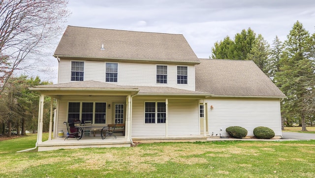 rear view of house featuring a yard and a shingled roof