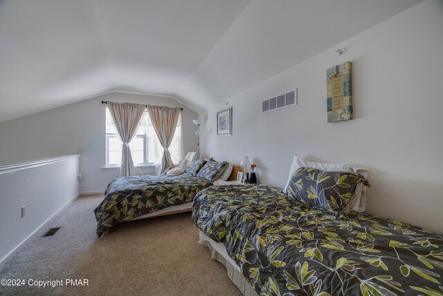 carpeted bedroom with baseboards, visible vents, and vaulted ceiling