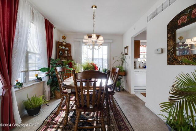 dining room featuring carpet floors, baseboards, visible vents, and a notable chandelier