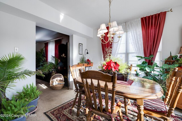 carpeted dining space featuring a chandelier