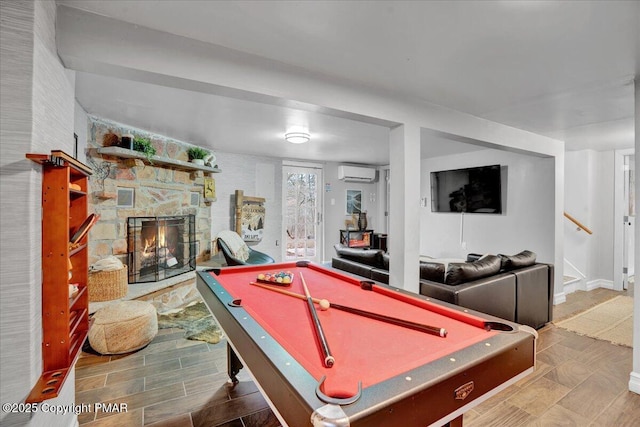 game room with a stone fireplace, a wall mounted air conditioner, billiards, and visible vents