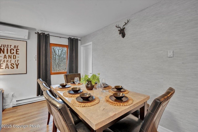 dining room with an AC wall unit and light hardwood / wood-style floors