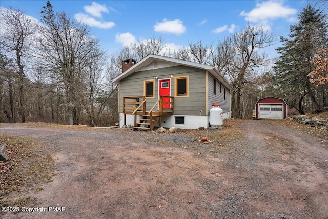 view of front of property featuring a garage and an outbuilding