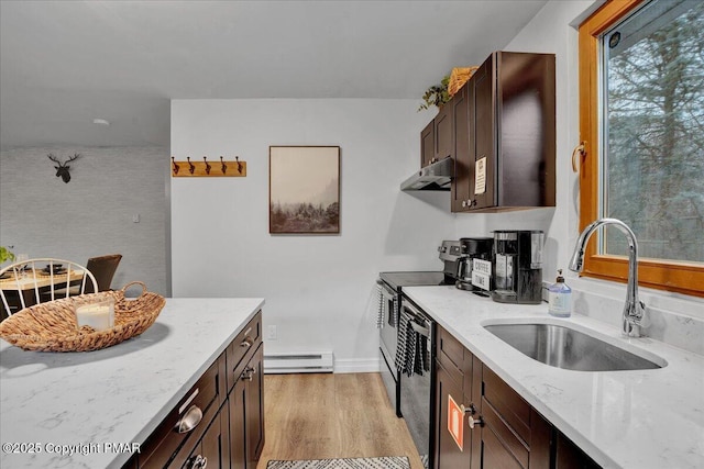 kitchen featuring black dishwasher, sink, light stone counters, baseboard heating, and light wood-type flooring