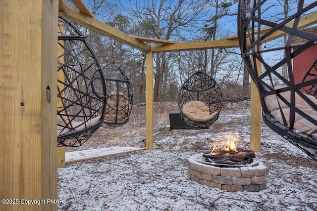 snow covered patio with a fire pit