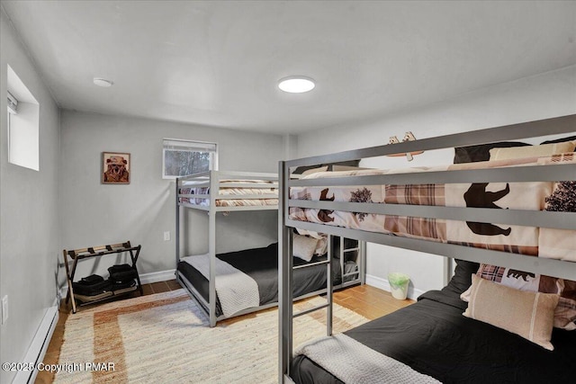 bedroom featuring a baseboard radiator and light hardwood / wood-style floors