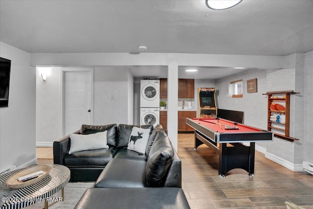 recreation room featuring hardwood / wood-style flooring, stacked washer and dryer, and pool table