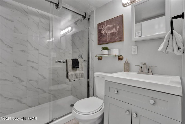 bathroom featuring vanity, toilet, and a shower with shower door