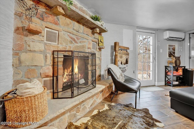 living room featuring a stone fireplace and a wall mounted AC