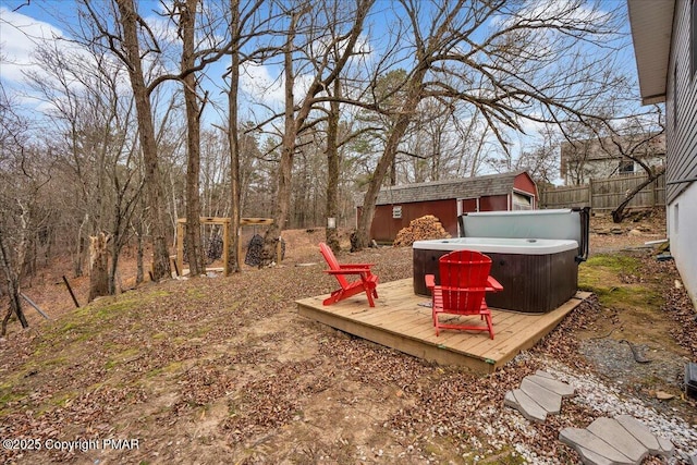 view of yard featuring a wooden deck, a hot tub, and a storage unit