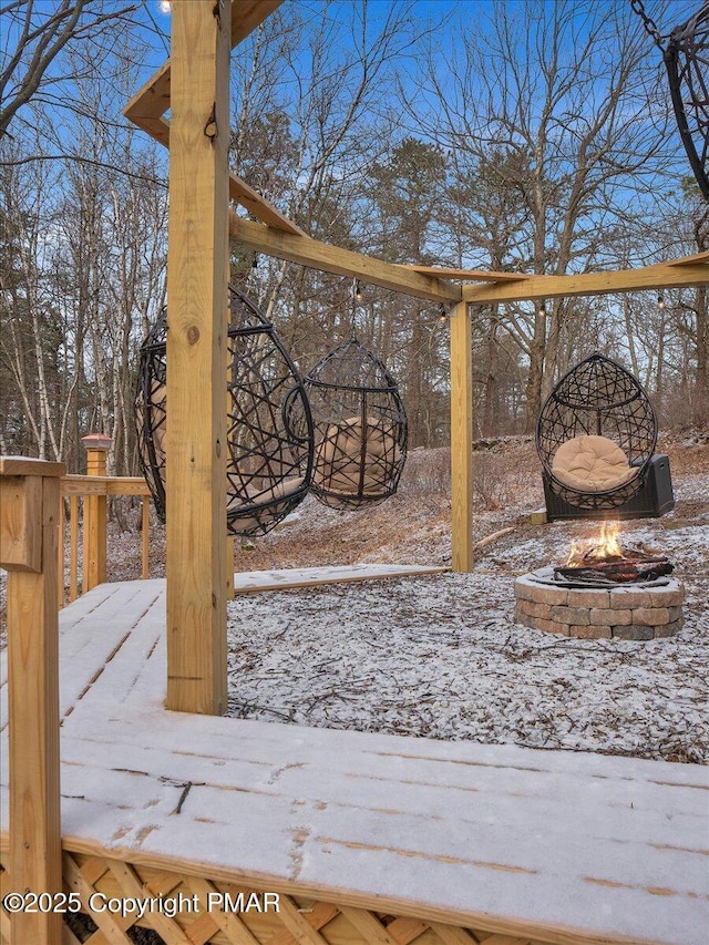 snow covered deck featuring a fire pit