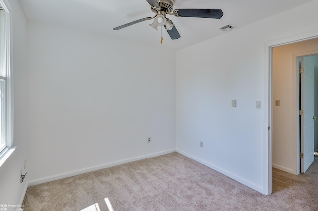 spare room featuring baseboards, carpet flooring, ceiling fan, and visible vents