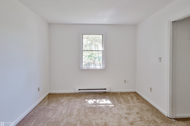 spare room featuring baseboards, carpet, and a baseboard heating unit