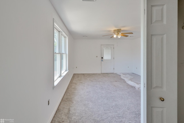 carpeted spare room featuring a ceiling fan, baseboards, and visible vents
