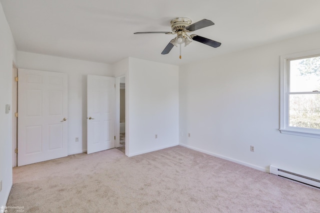 unfurnished bedroom with light colored carpet, a baseboard radiator, baseboards, and ceiling fan