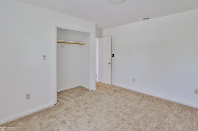 unfurnished bedroom with carpet flooring, baseboards, visible vents, and a closet