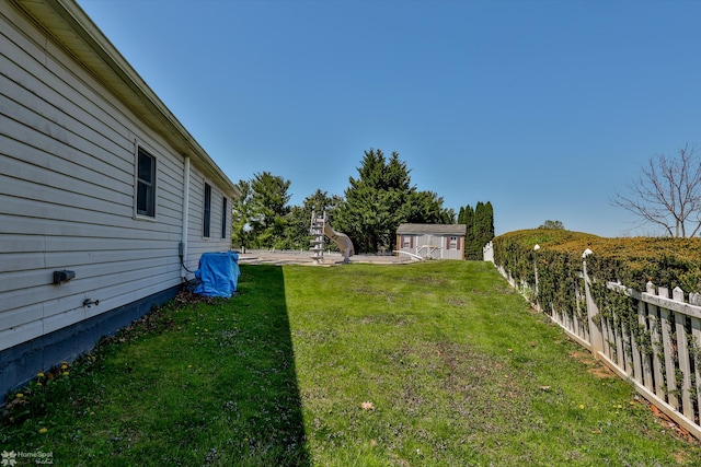 view of yard featuring fence and an outbuilding