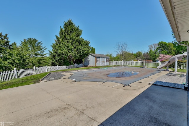 view of pool with fence, a water slide, and a patio area