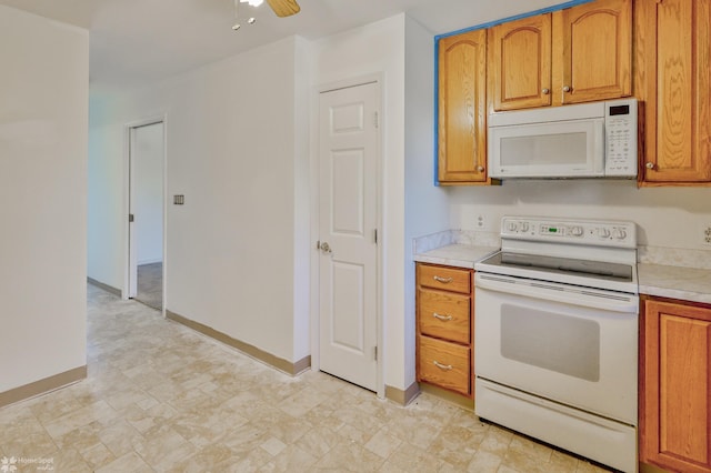 kitchen with ceiling fan, brown cabinetry, light countertops, baseboards, and white appliances