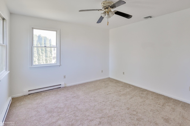 carpeted spare room with baseboard heating, visible vents, a ceiling fan, baseboards, and a baseboard heating unit