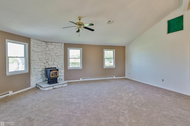 unfurnished living room featuring a ceiling fan, visible vents, baseboard heating, a wood stove, and carpet