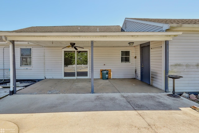 rear view of property featuring ceiling fan, roof with shingles, and a carport