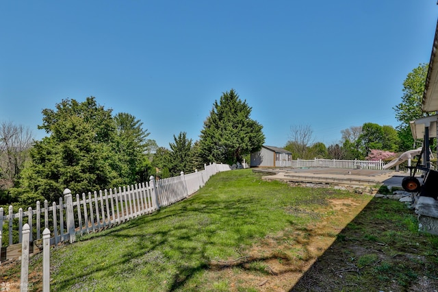 view of yard featuring a deck, an outbuilding, fence private yard, and a shed