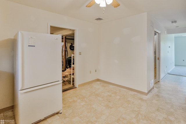 spare room featuring ceiling fan, visible vents, and baseboards