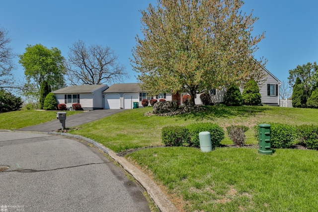 view of front of property with a garage, aphalt driveway, and a front yard