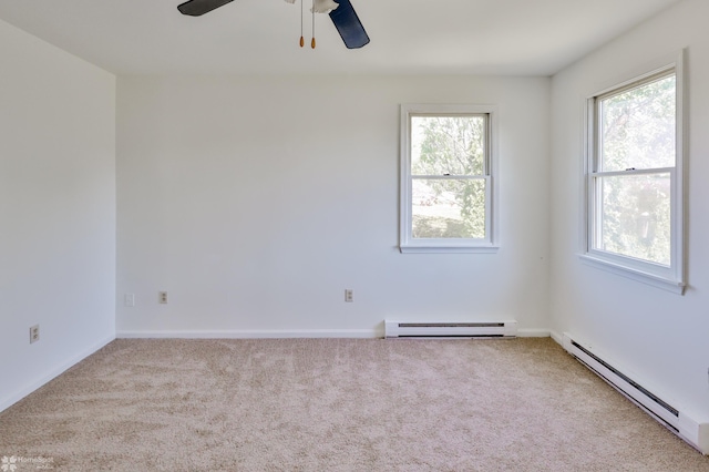 spare room with carpet, baseboard heating, and a wealth of natural light