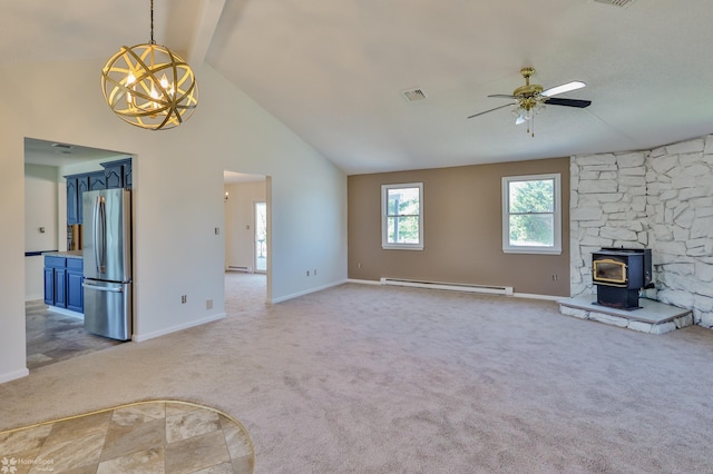unfurnished living room with light colored carpet, baseboard heating, a wood stove, high vaulted ceiling, and ceiling fan with notable chandelier