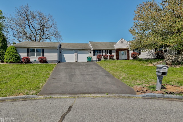 view of front facade with a garage, aphalt driveway, and a front yard