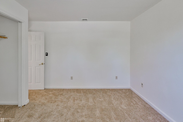 carpeted empty room with baseboards and visible vents