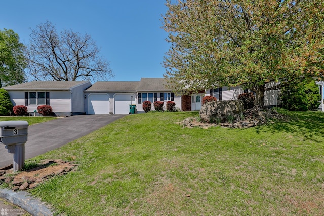 ranch-style home featuring aphalt driveway, a front yard, and a garage