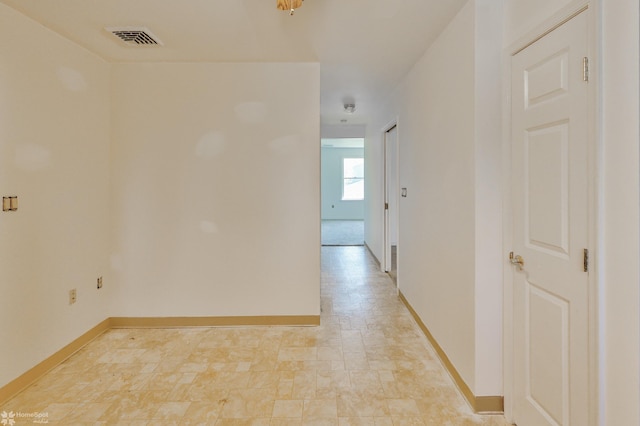 unfurnished room with baseboards and visible vents