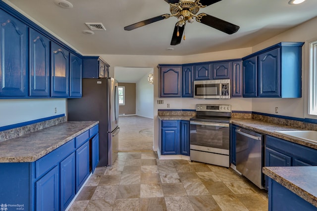 kitchen with visible vents, ceiling fan, blue cabinets, stone finish flooring, and appliances with stainless steel finishes