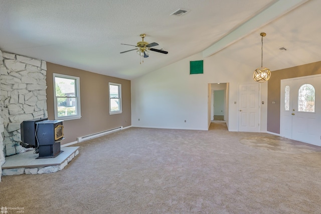 unfurnished living room with visible vents, a wood stove, carpet flooring, lofted ceiling with beams, and a baseboard radiator