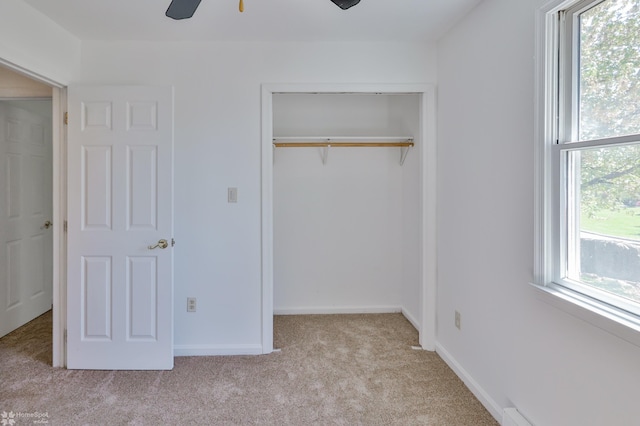 unfurnished bedroom featuring baseboards, ceiling fan, carpet, and a closet