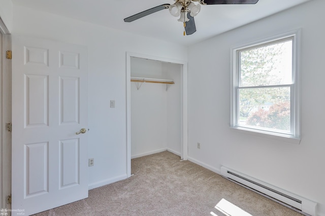 unfurnished bedroom featuring carpet floors, baseboards, a baseboard heating unit, and a closet